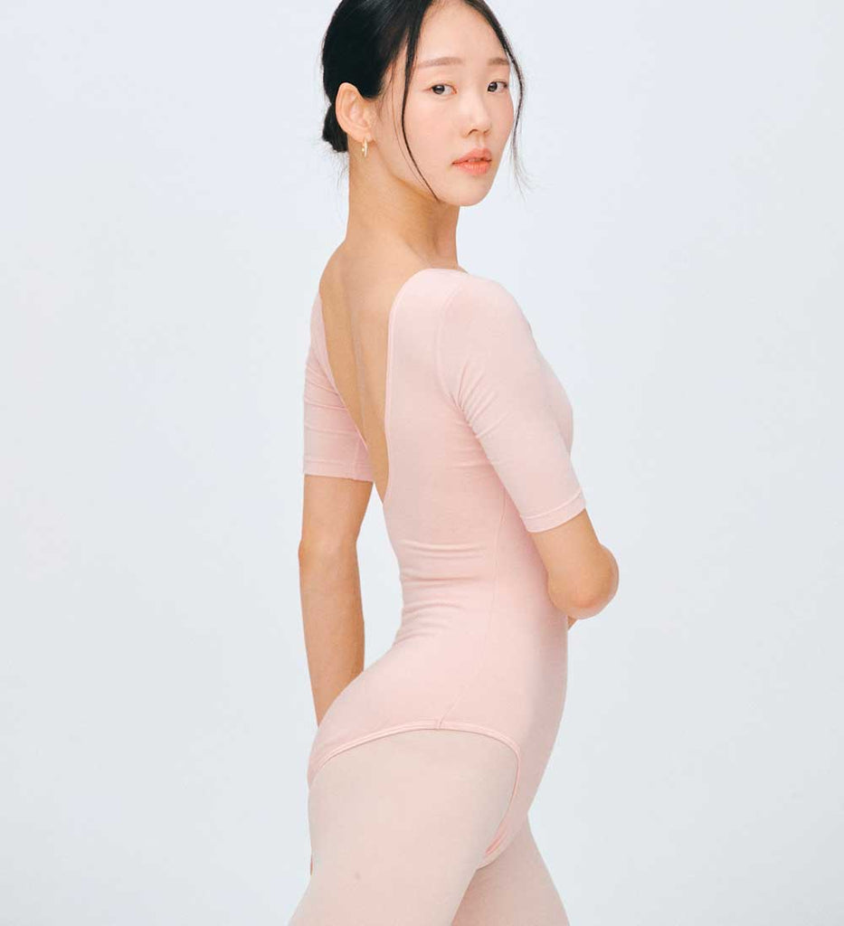 Detail of the ballet pink MODAL® wrapped top’s fitted shape and waist tie